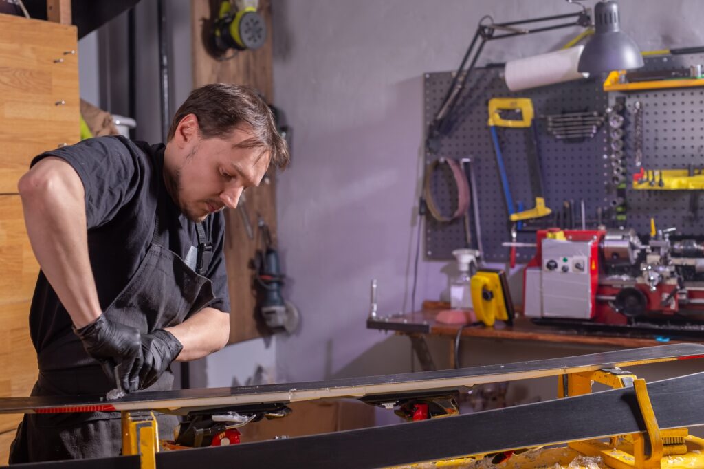 A man repairing the ski in the service